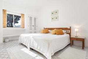 Una habitación blanca con una cama y una ventana en Villa Rosa, en Vale do Lobo