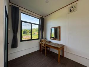 Zimmer mit einem Tisch und einem Fenster in der Unterkunft ເຂົ້າໜຽວຟາມສະເຕ-Kao Niaw Farmstay in Luang Prabang