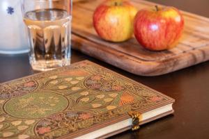dos manzanas en una mesa con un libro y un vaso de agua en Kleine Perle, en Donaurieden 21 fotos más