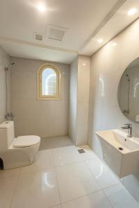 a white bathroom with a toilet and a sink at شاليه الحمرا 2-12بدرة العروس in Jeddah