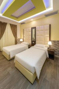 two beds in a hotel room with two lamps at شاليه الحمرا 2-12بدرة العروس in Jeddah