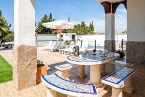 a patio with a table and chairs and an umbrella at Las Alas del Sol 2 in Vejer de la Frontera