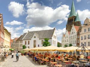 a group of people sitting at tables in a street at Speicherapartment in Warendorf