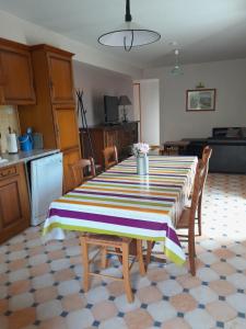 a kitchen with a table with a striped table cloth on it at la fontaine bénite in Seyssel