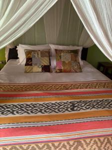 ein Bett in einem Zelt mit Kissen darauf in der Unterkunft UTOPIA in Gili Air