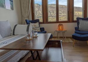 a living room with a couch and two glasses on a table at Reflet Bleu du Lac d'Annecy 3 étoiles - Face au lac, Parking gratuit, Paddle board in Doussard +61 photos