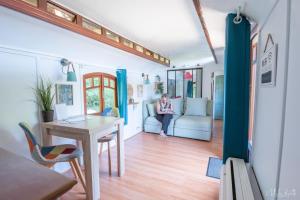 a woman sitting on a couch in a living room at La roulotte de Fichous in Fichous-Riumayou