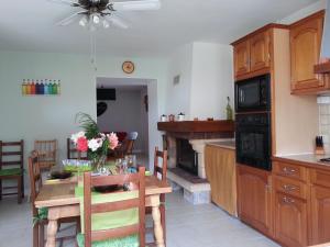 a kitchen and dining room with a table and a fireplace at Le gîte de Gemma in Montain +5 photos