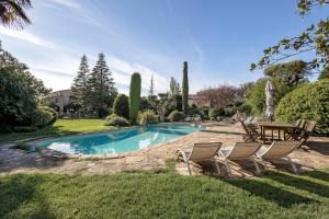 a swimming pool in a yard with chairs and a table at Casa Farigola in El Bruc