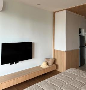 a bedroom with a flat screen tv on a wall at Studio in a modern complex Wing Samui Condo in Amphoe Koh Samui