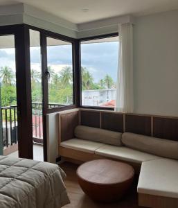 a living room with a couch and a large window at Studio in a modern complex Wing Samui Condo in Amphoe Koh Samui