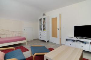 een woonkamer met een bed en een flatscreen-tv bij Das kleine Ferienglück in Salem