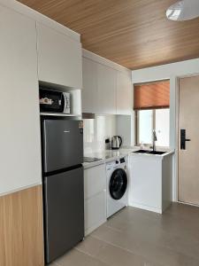a kitchen with a refrigerator and a washer and dryer at Studio in a modern complex Wing Samui Condo in Amphoe Koh Samui
