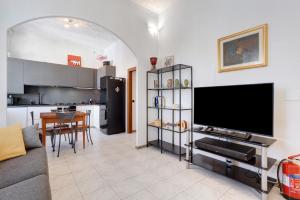 a living room with a tv and a kitchen at La dimora del Gallo in Concorezzo