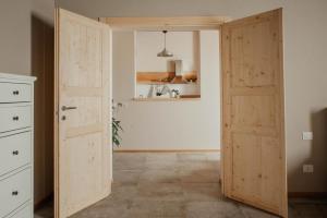 a room with two wooden doors in a room at La Cocca Home in Bellinzago Novarese