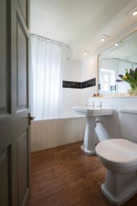 a bathroom with a toilet and a sink and a mirror at The Winning Post in Windsor