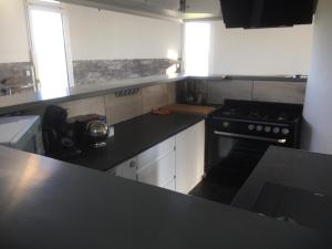 a kitchen with a black counter top and a stove at chateau d'eau le sable in Daon