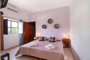 a bedroom with a bed and a clock on the wall at Casa dos Jotas in Martinlongo