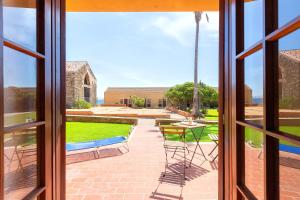 una ventana con vistas a un patio con mesa y sillas en Casa Claudia Le Tonnare Stintino, en Stintino