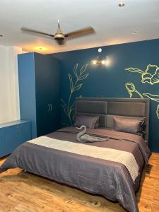 a bedroom with a large bed with a blue wall at Crown plaza hotel and cafe in Kasol +8 photos