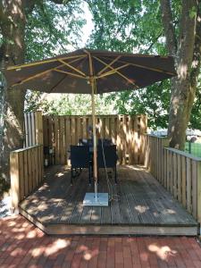 BreklumにあるHaus An Der Marschの傘の下にテーブルがある木製のデッキ