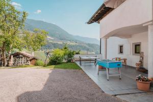 a patio with a ping pong table on the side of a house at Oberegghof Ferienwohnung Hirzer in Rifiano