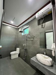 a bathroom with a shower and a toilet and a sink at Tam Coc Mountain Light Homestay in Ninh Binh