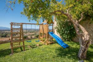 een speeltuin met een glijbaan en een boom bij Luxury Finca Es Moli in Ariany