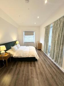 a bedroom with a bed and a large window at Barnet House Serviced Apartments in Dunfermline