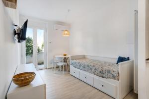 Fiumaretta di AmegliaAppartamento 2的一间带床和桌子的白色卧室