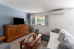 Robion en LuberonにあるLa Maison des Oliviersのソファとテレビのあるリビングルーム