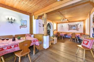 a dining room with tables and chairs in a building at Birkenhof - Wohnung Bichel in Sluderno