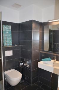 une salle de bains avec toilettes et lavabo dans l'établissement Cliff Apartment, à Brodten