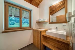 Un baño con lavabo y ventana. en Ferienhaus Larch Soge Apt Helmuth, en Racines 15 fotos más
