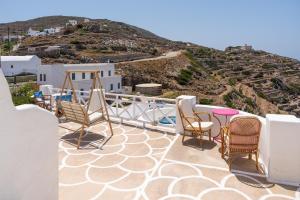 a balcony with chairs and a view of a hill at Antiparos - Sikinos Sunset in Síkinos