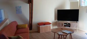 a living room with a couch and a flat screen tv at La Pause Picarde - Baie De Somme 2 in Franleu