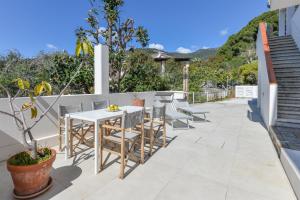 Un patio con una mesa y sillas blancas. en Casa Magnolia Loft, en Seccheto