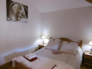 een slaapkamer met een bed met twee lampen en een afbeelding van een hond bij Logis Des Cerfs in Puyvalador