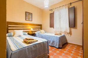 ein Schlafzimmer mit zwei Betten und einem Fenster in der Unterkunft Esencia Del Paladin in Zufre