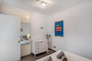 サン・バルトロメにあるApartamento Yumbo Playa Del Inglesの白いベッドルーム(ベッド1台、ドレッサー、鏡付) +14枚の写真