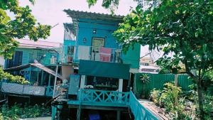a blue house with a fence in front of it at New Phiman Riverview Guesthouse in Bangkok