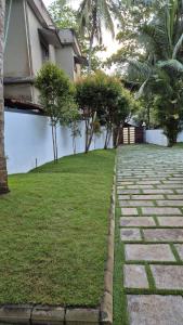 a stone path in front of a house at Thistle Cosy Villa in Kozhikode