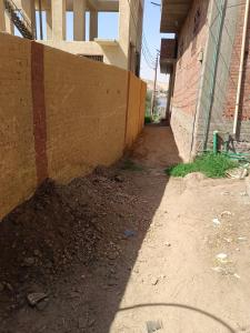 an alley with a brick wall next to a building at Venti house in Aswan