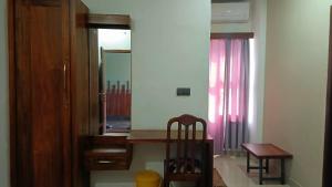 a room with a mirror and a table and a chair at Nelleri Residency ROOMS STARTING AT 999 in Iritti