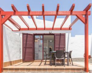 Una pequeña casa con una mesa y sillas en una terraza. en Casita Del Sol, en Caleta de Fuste