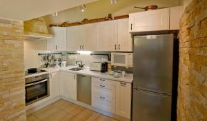 eine Küche mit weißen Schränken und einem Edelstahlkühlschrank in der Unterkunft Perfect To Relax in Algoz + 9 Fotos