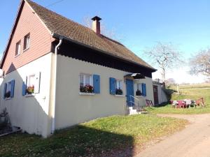 a white house with blue shutters and a table at Hofgut Dürrenbühl in Grafenhausen