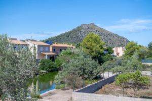 a river with houses and a mountain in the background at Que Bo in Alcudia