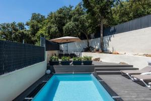 a swimming pool with chairs and an umbrella at Sestel in Capdepera