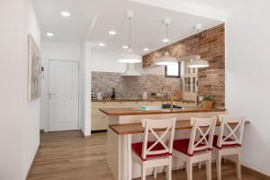 eine Küche mit einer Theke, Stühlen und einem Waschbecken in der Unterkunft Villa Berkana De Lujo Con Piscina in Playa Honda